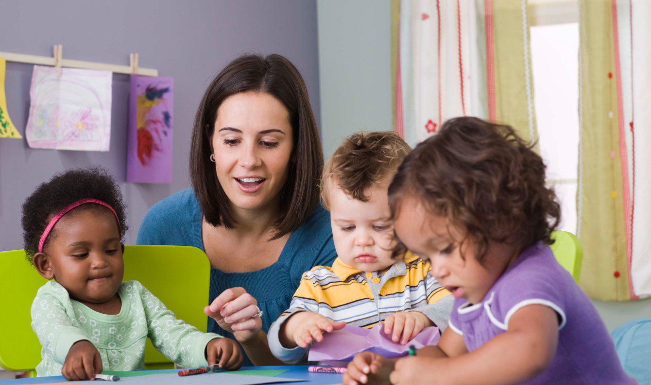 An early intervention service provider working with three toddlers in a classroom